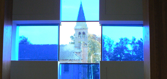 Door de ramen van de Mariakapel Geerdijk is de kerk zichtbaar